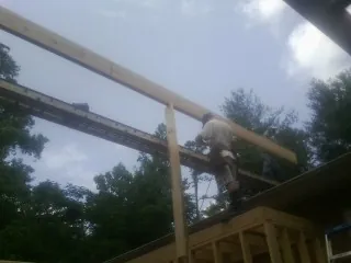 Carpenter setting a ridge beam over a new addition frame — Ice Dam Removal by Roofing Brothers in Senoia