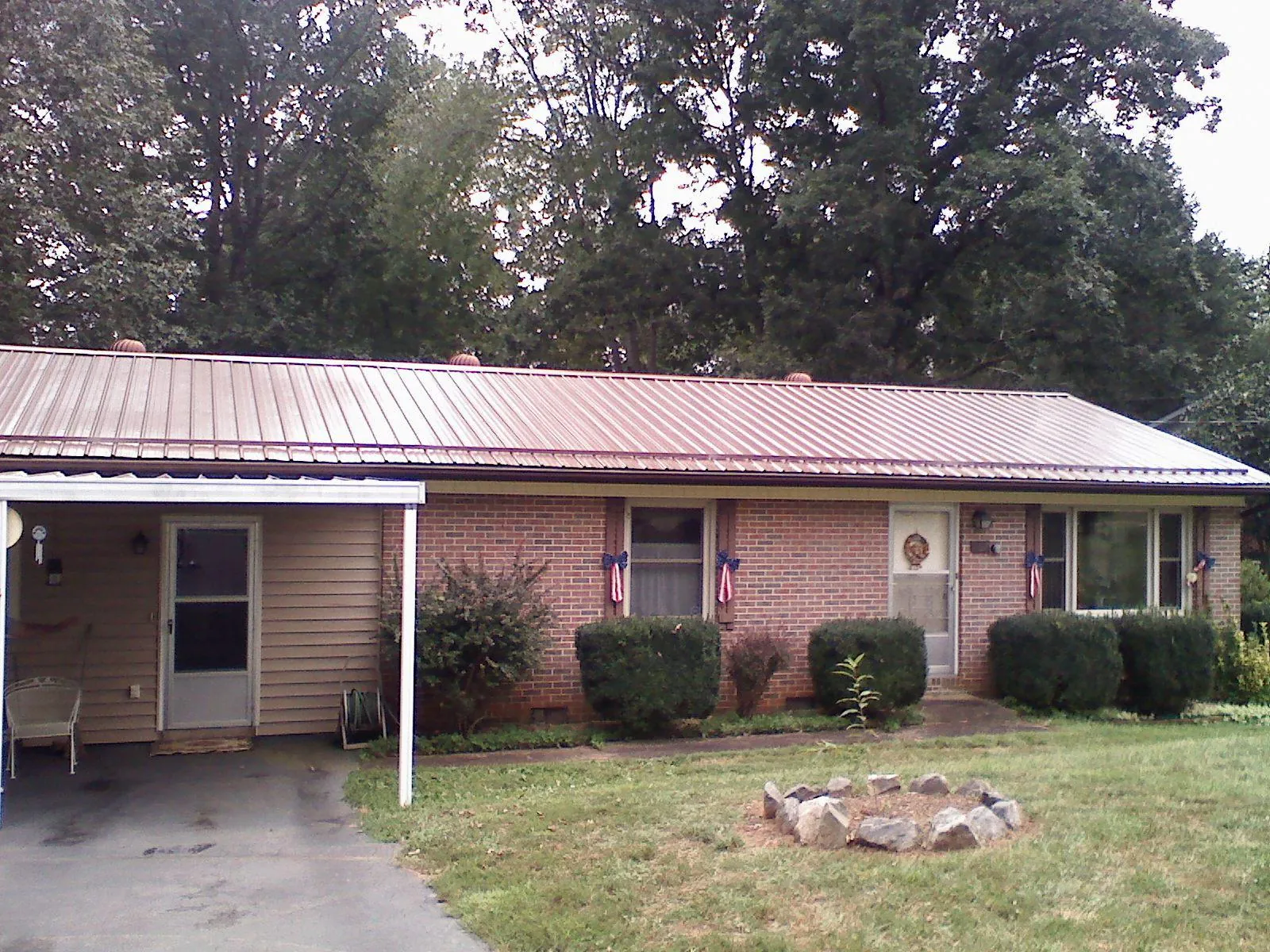 Bronze metal roof and carport on a brick ranch home — Roof Repair work by our crew in Senoia