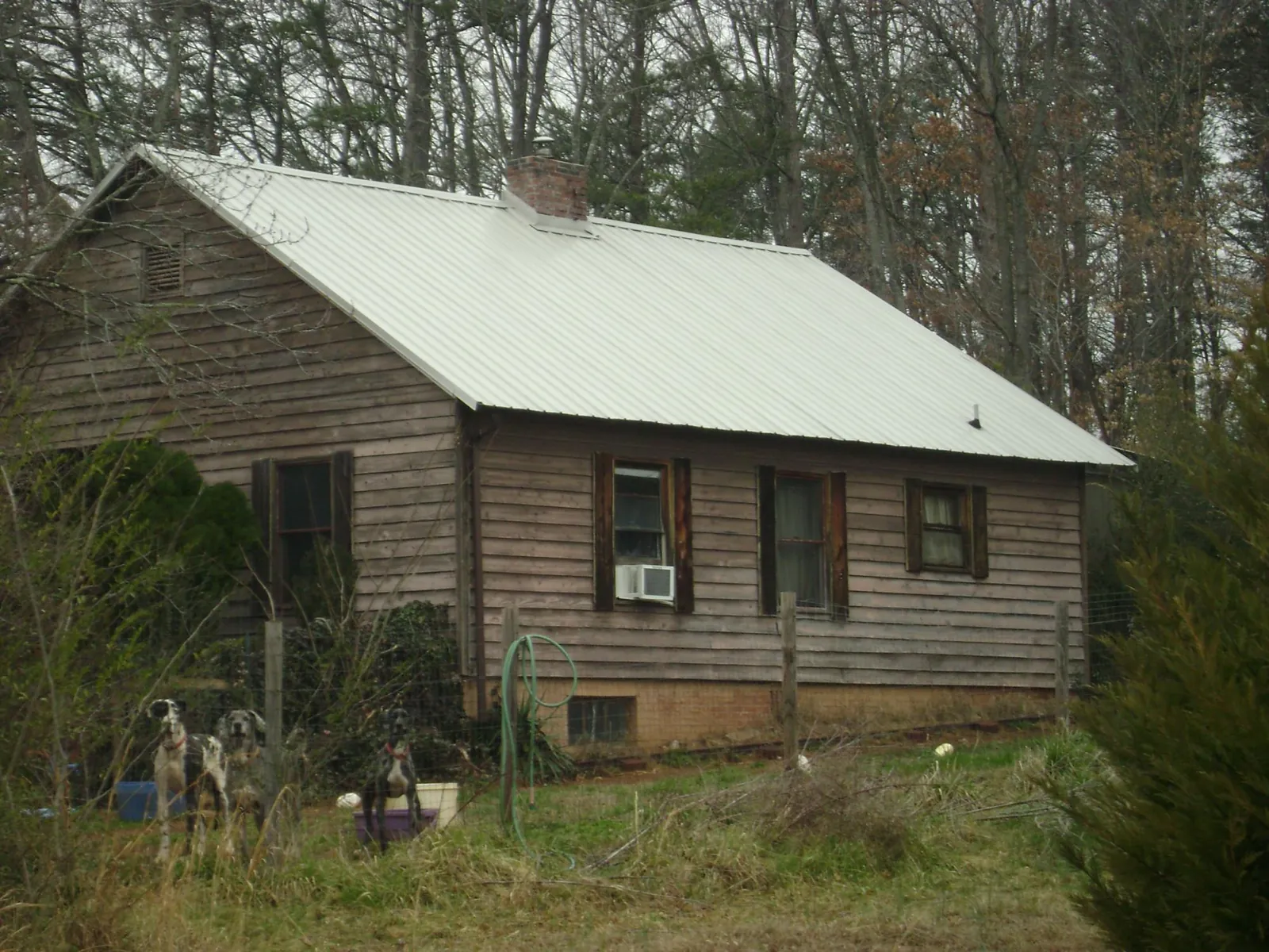 White metal roof on an old wood sided farmhouse, from a Asphalt Shingle Roof Repair job in Senoia
